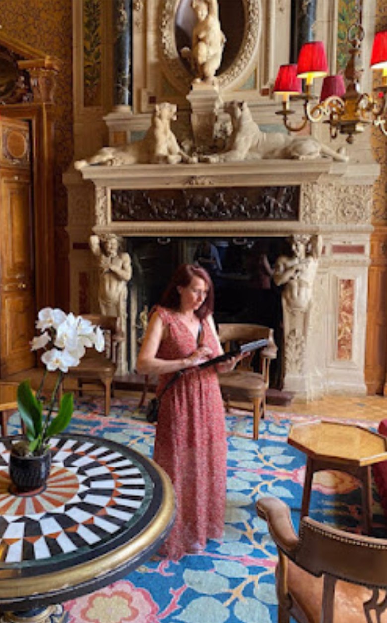 Isabelle Arnaud en visite, devant une cheminée sculptée